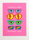 This image is a greeting card by Kiosk that has a pink background. It has three pairs of illustrated glasses on it. The glasses have different shapes, colors, and patterns on the lenses. Above the top pair of glasses is the text “Looking Good”, and below the bottom pair is the text Birthday Babe”. The card has a playful and cheerful design that conveys a message of celebration and compliments for your birthday. 🎂